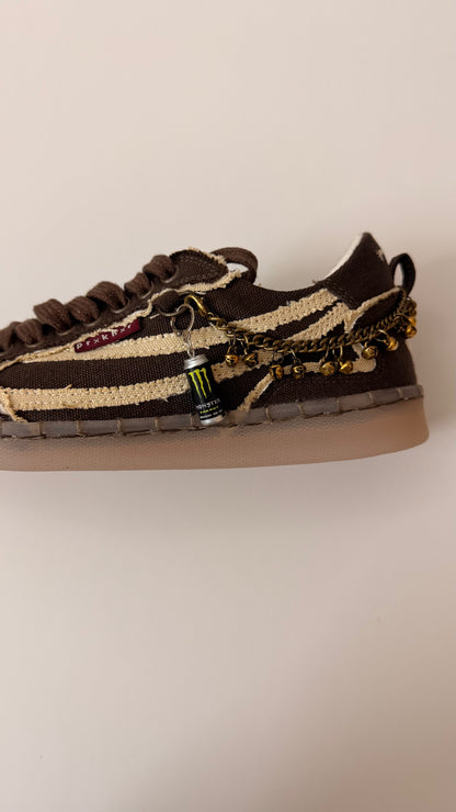 Black Monster Energy Shoe Charm, mini black Monster Energy can charm with the green claw logo on the laces of a brown canvas sneaker