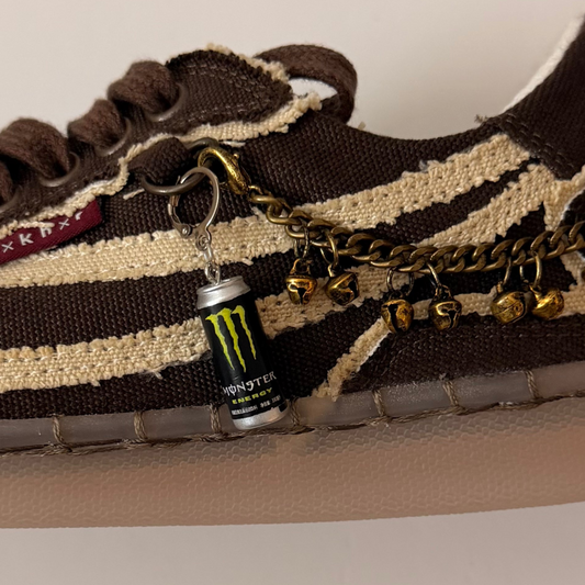 Black Monster Energy Shoe Charm, mini black Monster Energy can charm with the green claw logo on the laces of a brown canvas sneaker