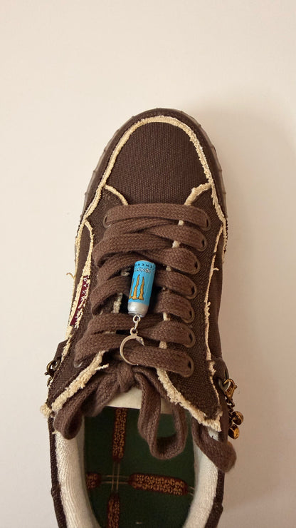 Blue Monster Energy Shoe Charm, mini light blue Monster Energy can charm on the laces of a brown canvas sneaker, from the heel