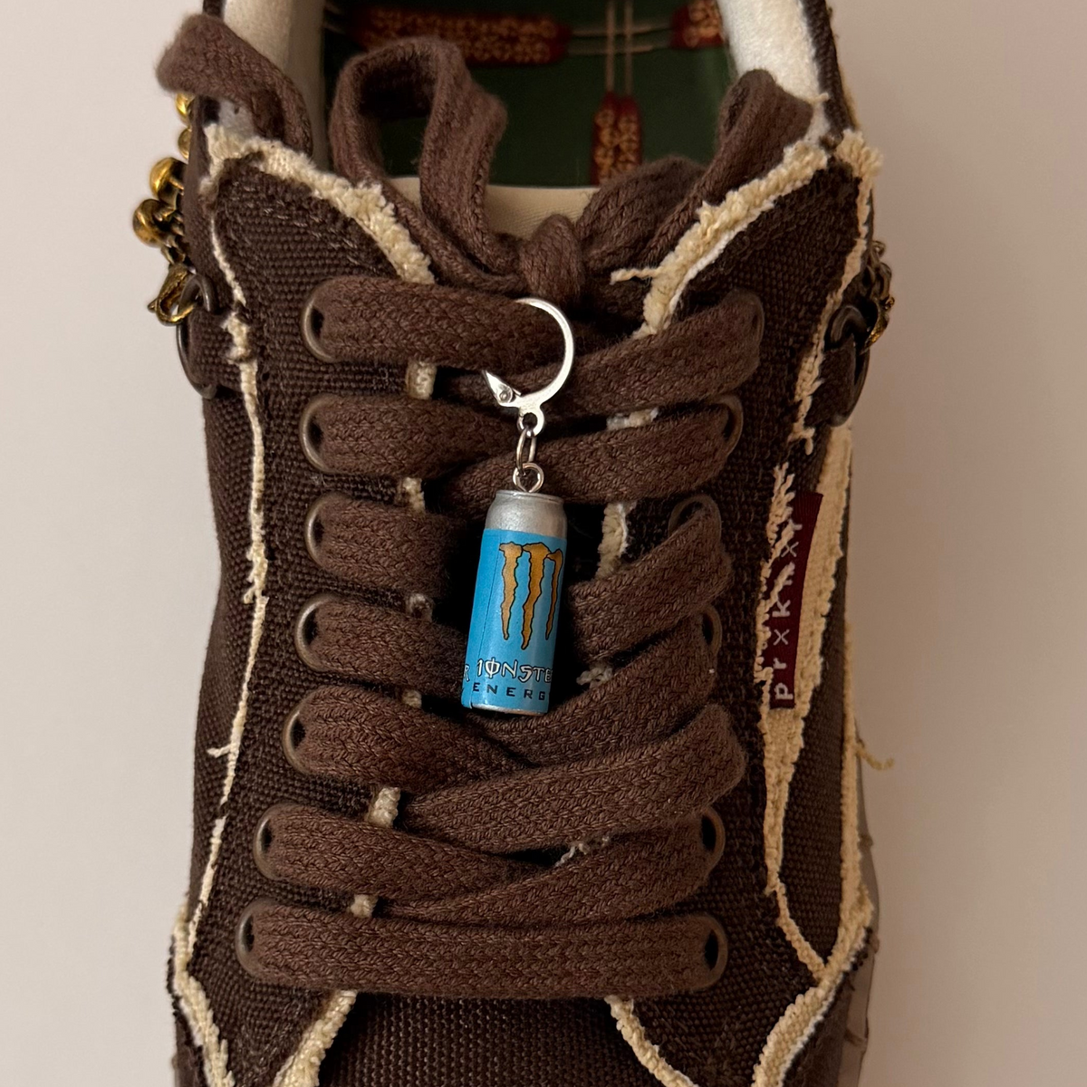 Blue Monster Energy Shoe Charm, mini light blue Monster Energy can charm on the laces of a brown canvas sneaker