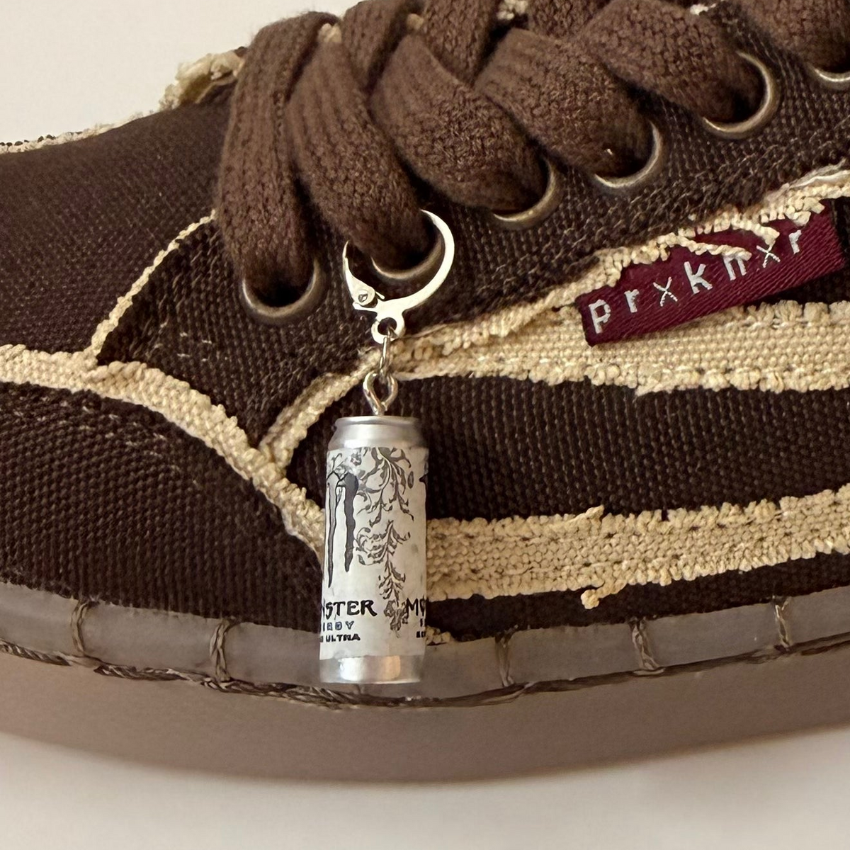 White Monster Energy Shoe Charm, mini white Monster Energy Ultra can charm on the laces of a brown canvas sneaker