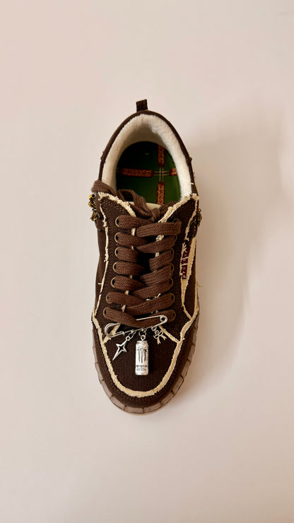 No Sleep Club, brooch pin fastened to the laces of a brown canvas sneaker