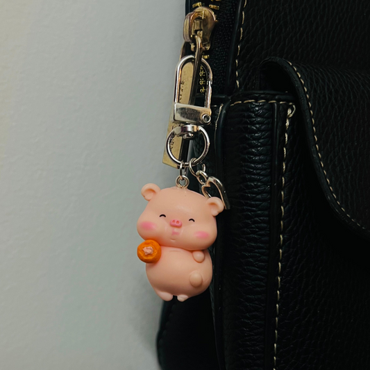 Pink Piggu piglet bag charm hugging a piece of fried chicken