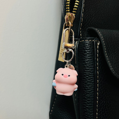 Pink Piggu piglet bag charm wrapped in a blue towel
