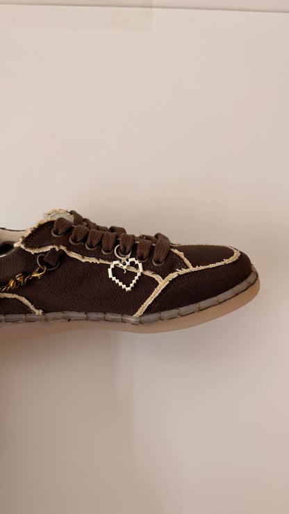 Pixel Heart Shoe Charm, open silver pixel heart charm on the laces of a brown canvas sneaker