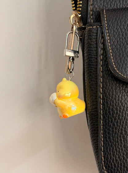 Quack & Snack, a yellow duck holding a white saucer shown from another angle.