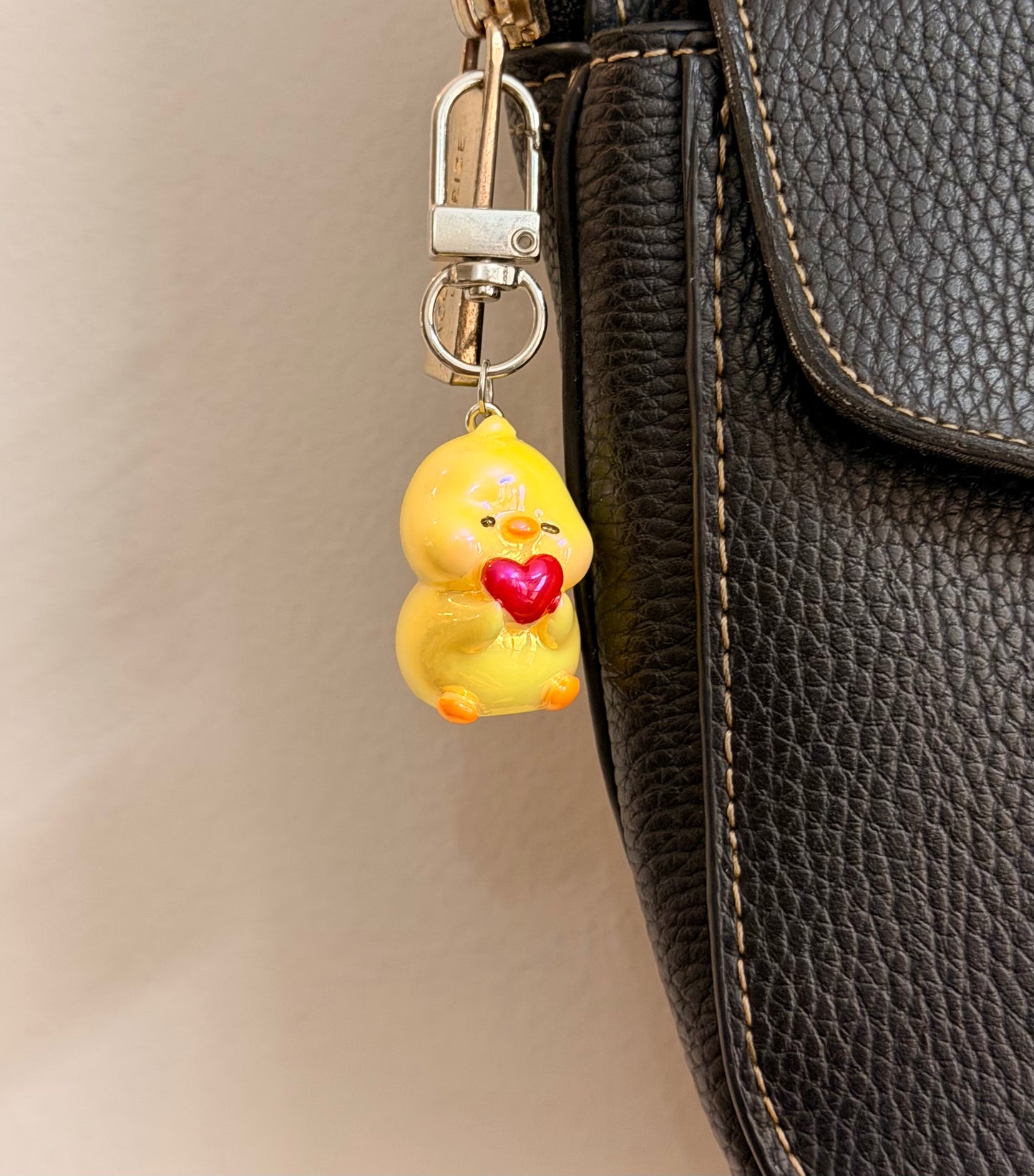 Quack in love, a yellow duck holding a red heart shown from another angle.