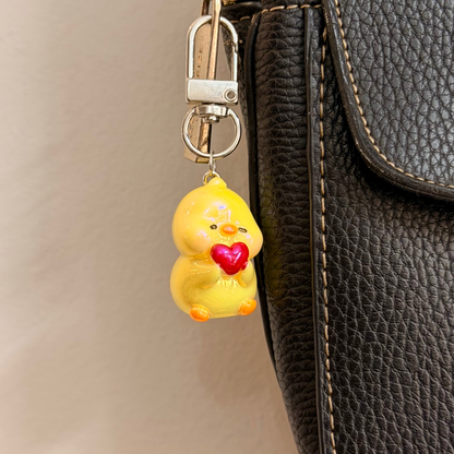 Quack in love, a yellow duck holding a red heart.