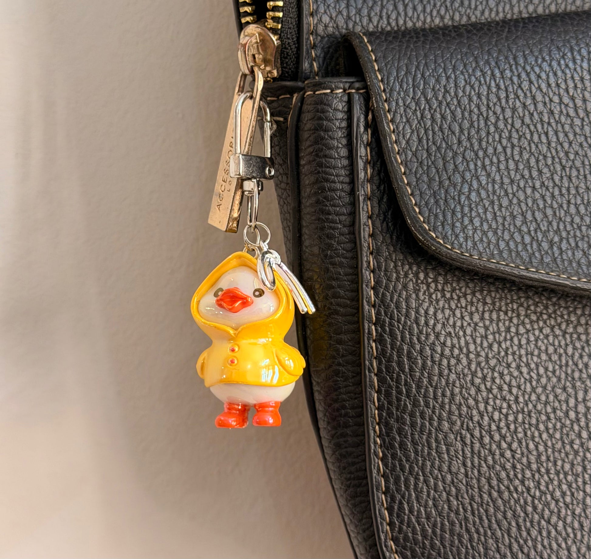 Rainy Day Duck, a yellow duck in a raincoat with the hood up and orange boots shown from another angle.