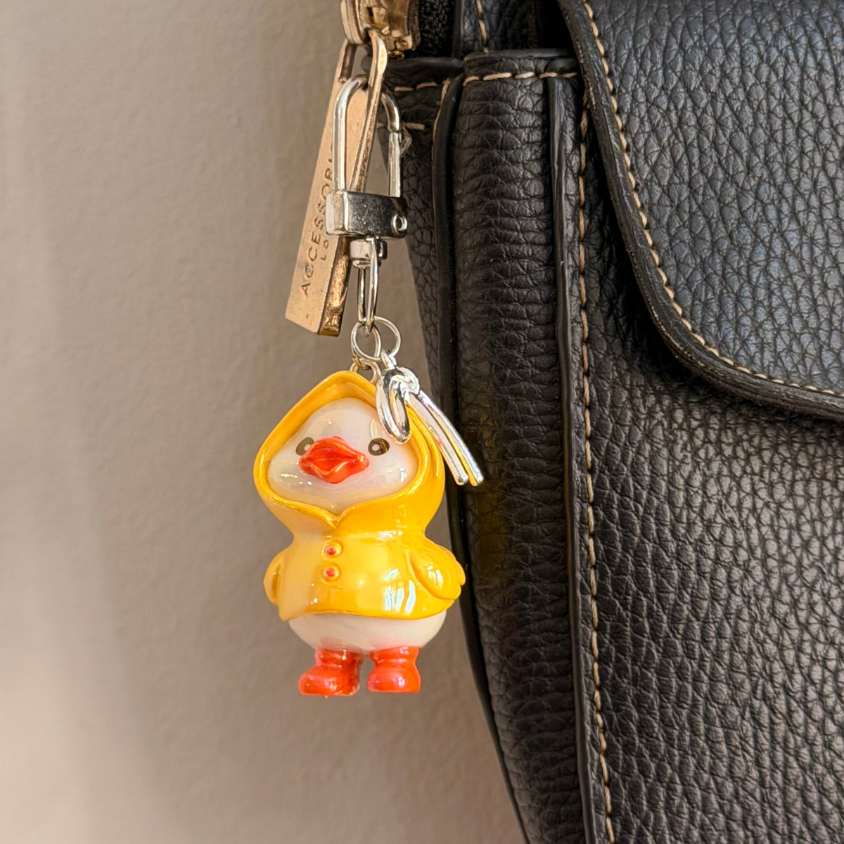 Rainy Day Duck, a yellow duck in a raincoat with the hood up and orange boots.