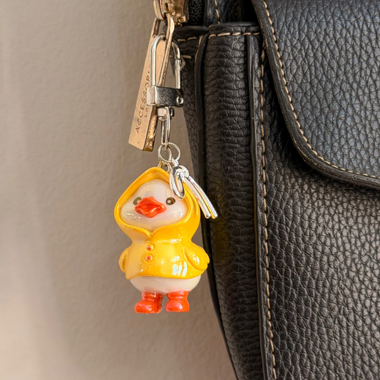 Rainy Day Duck, a yellow duck in a raincoat with the hood up and orange boots.
