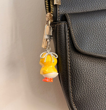 Rainy Day Duck, a yellow duck in a raincoat with the hood up and orange boots shown from another angle.