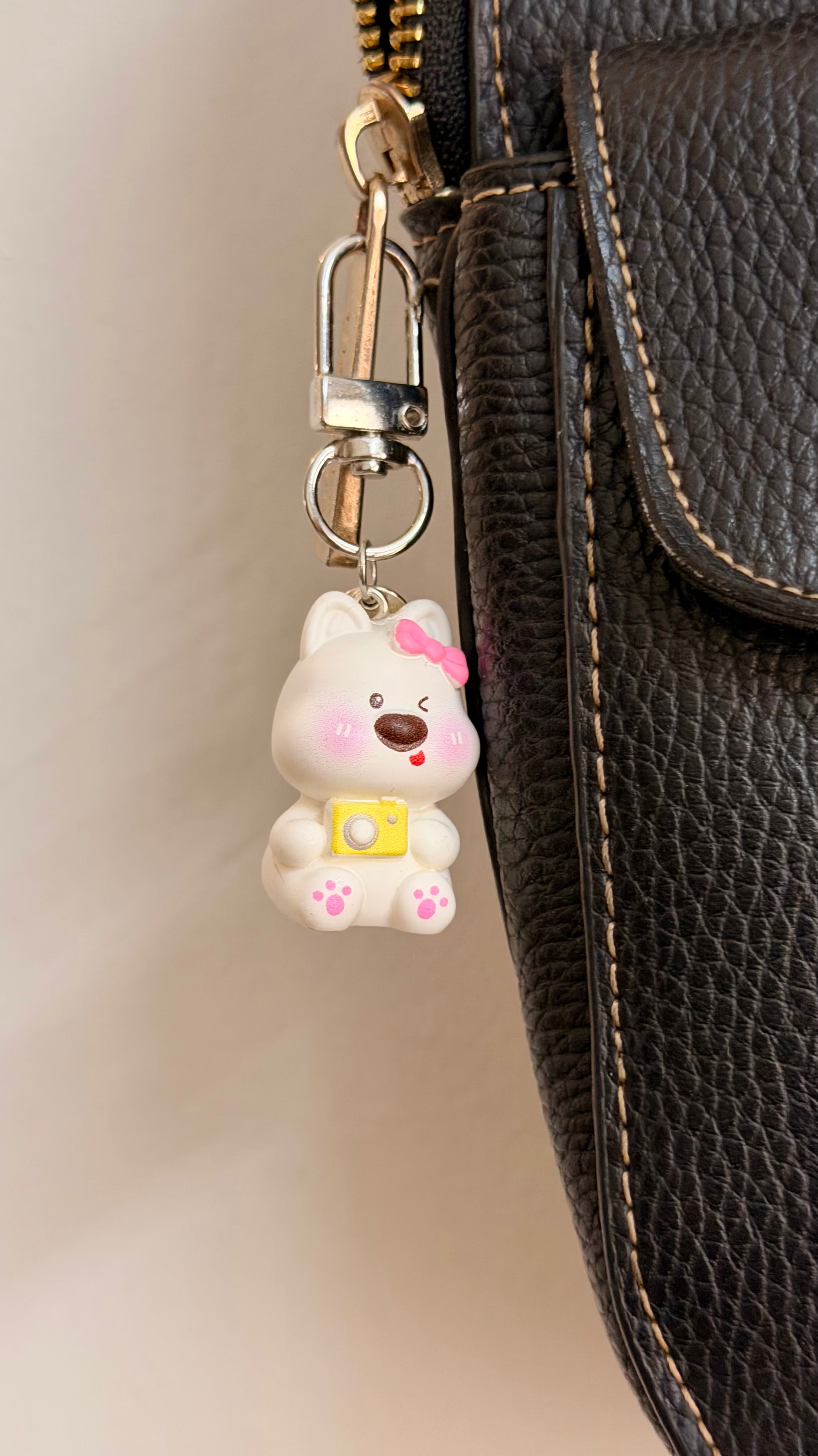 Say Cheese, a white puppy with a pink bow and a yellow camera shown from another angle.
