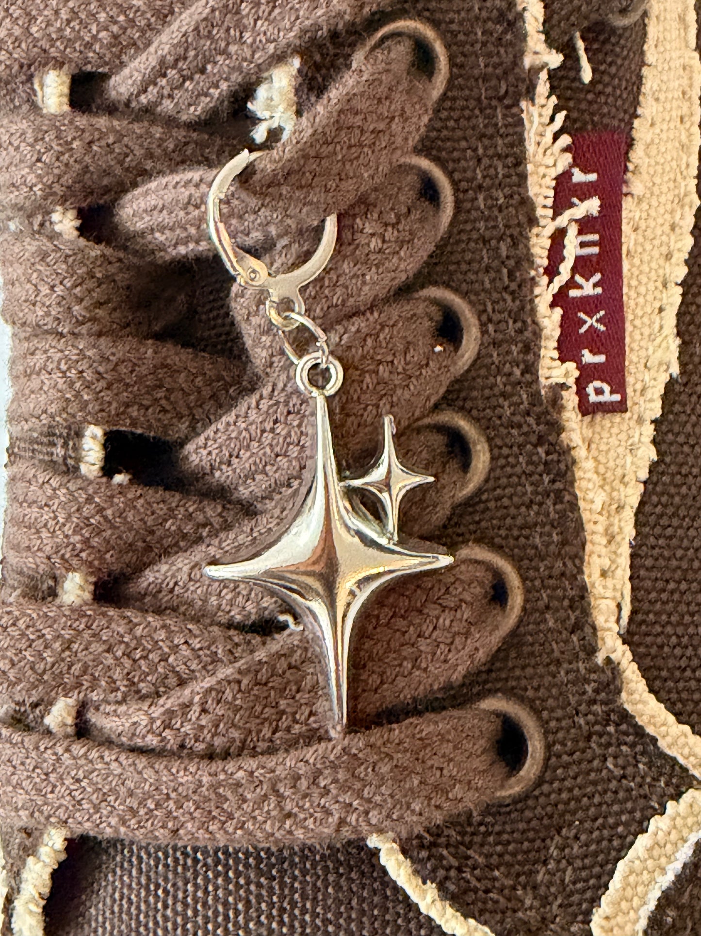 Starstruck Shoe Charm, puffy silver sparkle star charm on the laces of a brown canvas sneaker