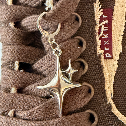 Starstruck Shoe Charm, puffy silver sparkle star charm on the laces of a brown canvas sneaker