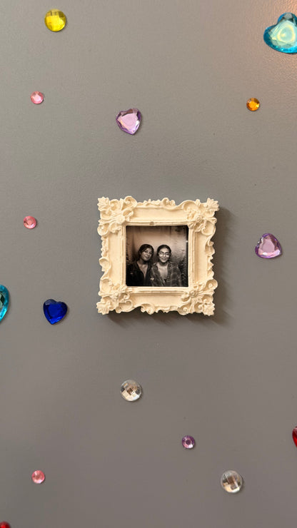 The Nostalgic Magnetic Frame, white concrete square frame with carved corner rosettes, holding a photo