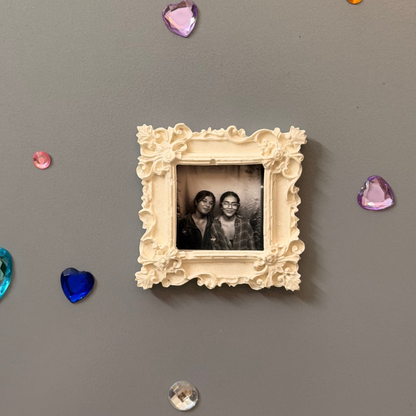 The Nostalgic Magnetic Frame, white concrete square frame with carved corner rosettes, holding a photo