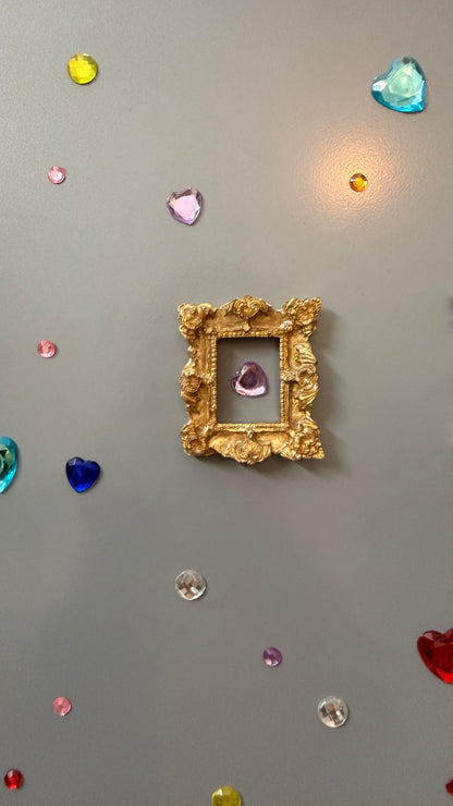The Relic Magnetic Frame, gold concrete miniature frame with rococo scrollwork around a small rectangular opening
