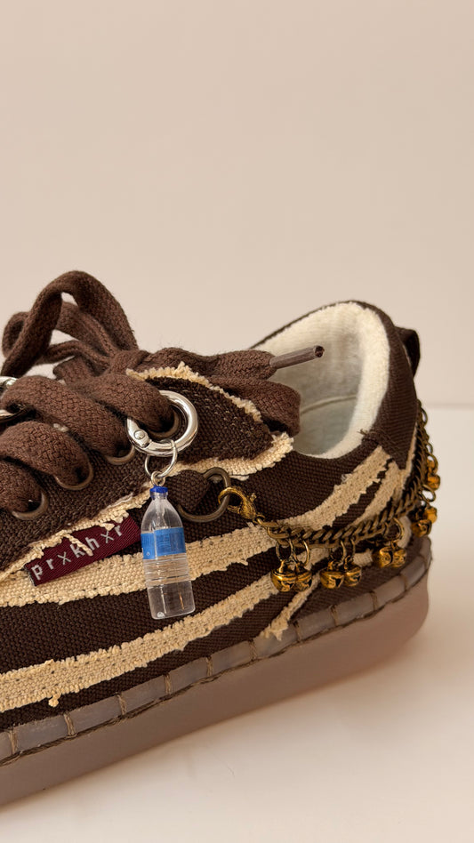 Water Bottle Shoe Charm, mini water bottle charm with a blue cap on the laces of a brown canvas sneaker