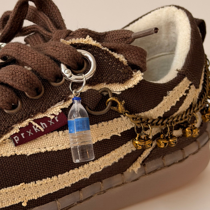 Water Bottle Shoe Charm, mini water bottle charm with a blue cap on the laces of a brown canvas sneaker