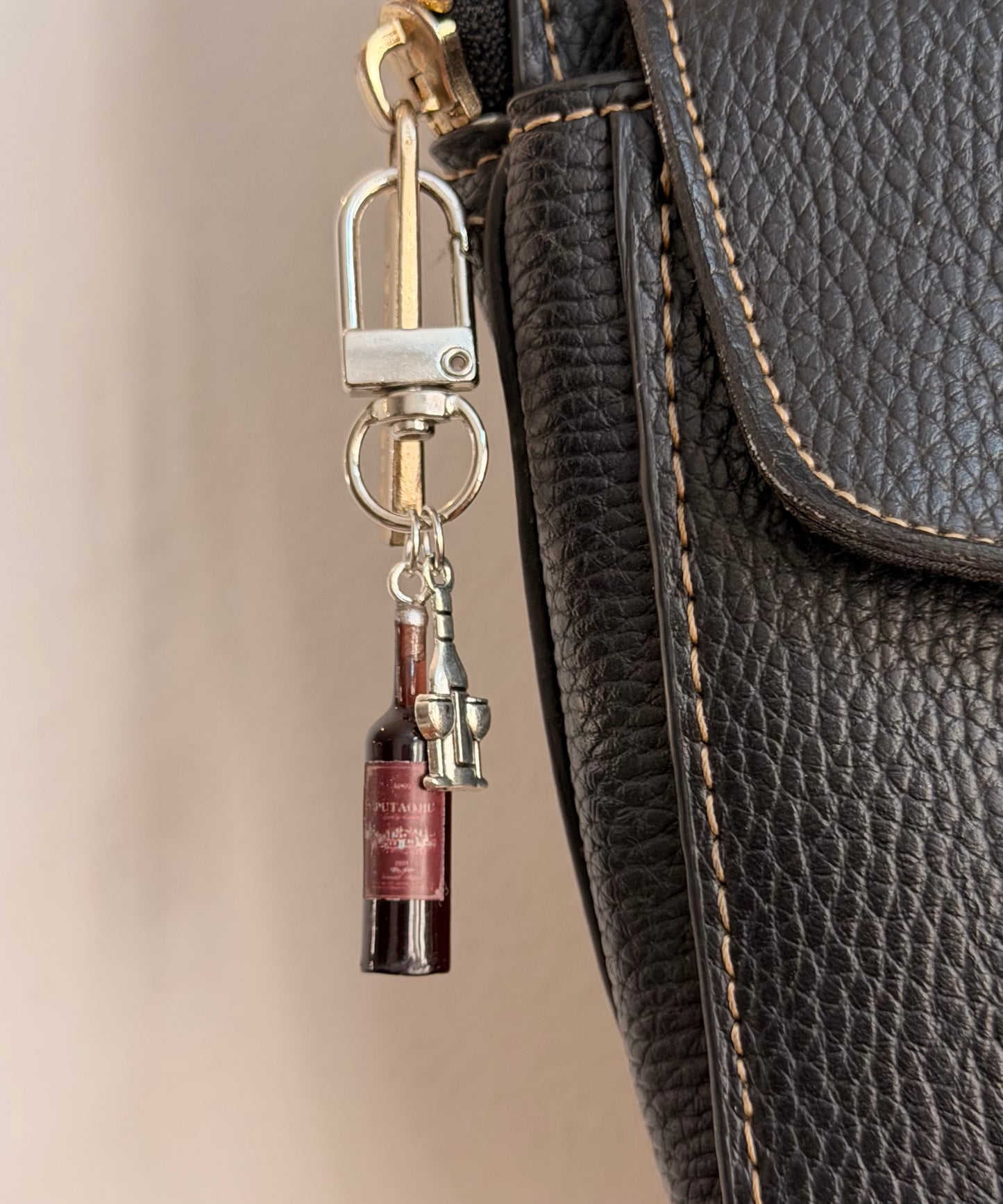 Wine O'Clock, a miniature red wine bottle with a silver corkscrew shown from another angle.