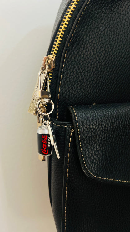 Black Coca-Cola Zero can charm with a silver thunderbolt on a bag clasp